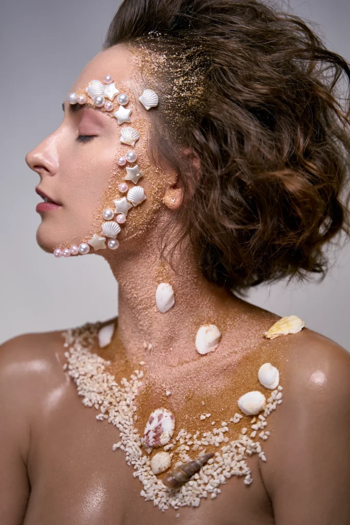 Beauty editorial sirena: perfil de modelo con pelo ondulado y conchas. Publicado en Malvie Magazine.