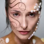 Fotografía Beauty Profesional en Mallorca | VR Creative Studio Beauty editorial: perfil de modelo con pelo mojado, brillo y arena. Publicado en Malvie Magazine, VR Creative Studio.