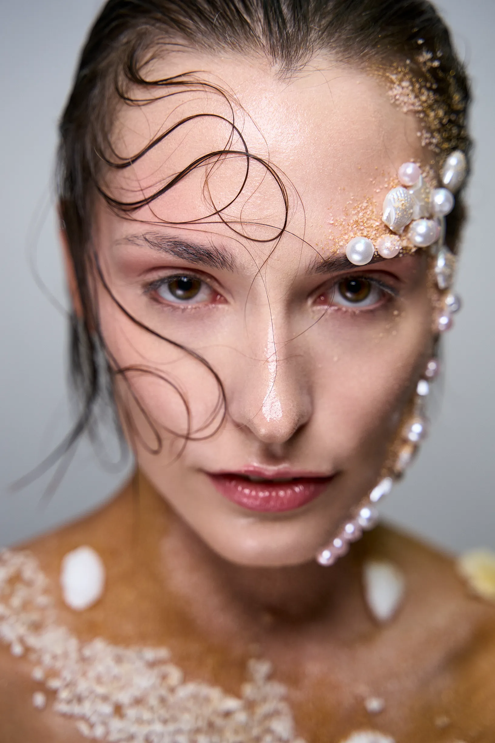 Beauty editorial: perfil de modelo con pelo mojado, brillo y arena. Publicado en Malvie Magazine, VR Creative Studio.