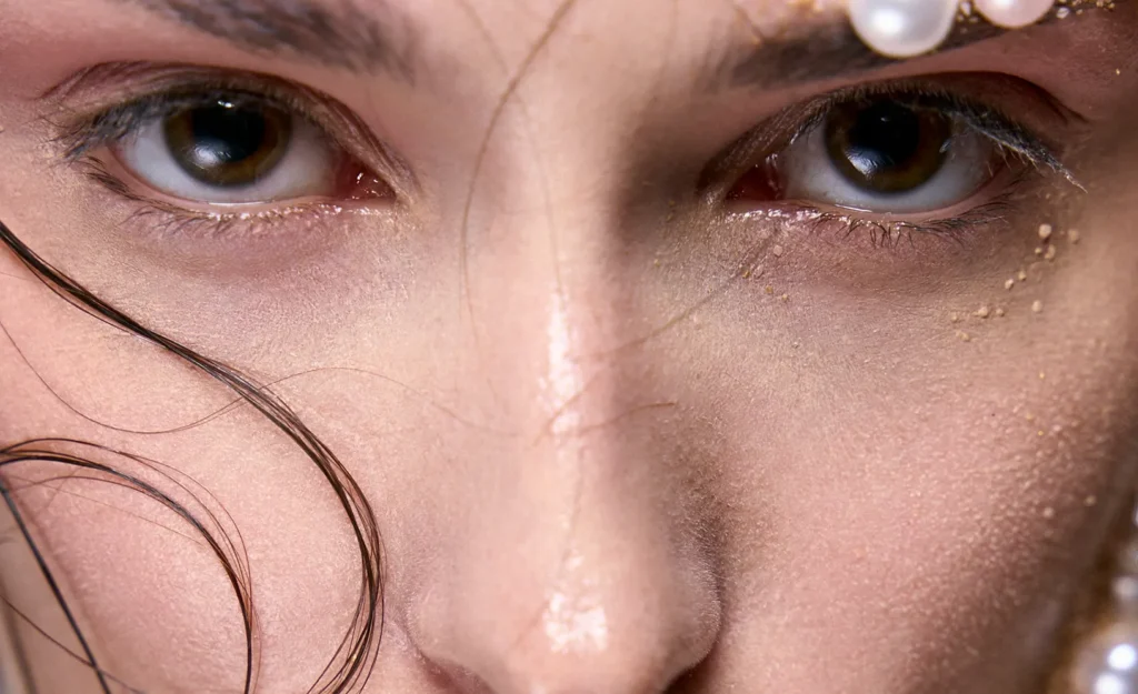 Primer plano macro de los ojos de una modelo con piel húmeda y perlas, fotografía de belleza profesional en Mallorca.
