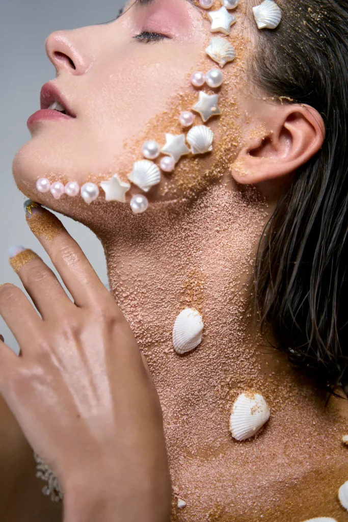 Editorial beauty sirena: perfil de modelo con ojos cerrados, conchas y arena. Publicado en Malvie Magazine.