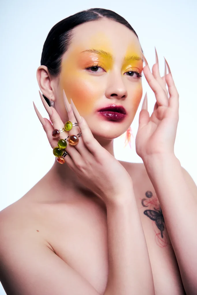 Primer plano de retrato beauty con maquillaje artístico amarillo y naranja inspirado en Hatsune.