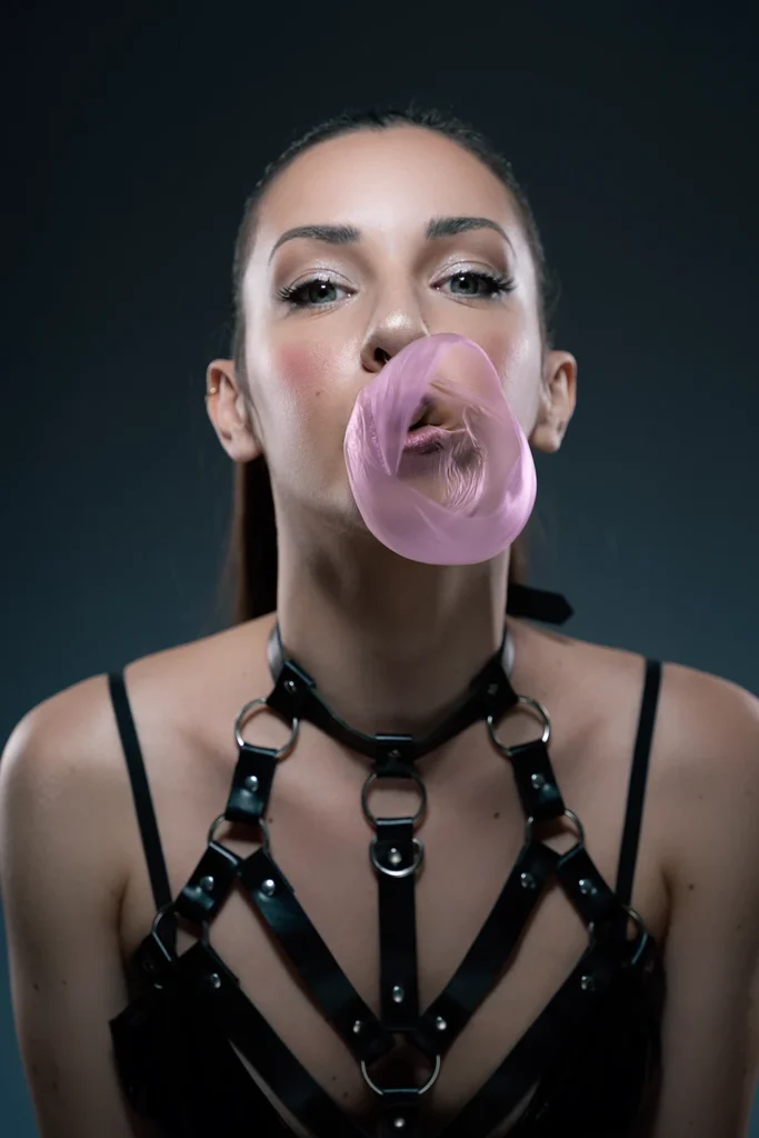 Modelo haciendo una pompa de chicle en una sesión para book de fotos alternativo y de moda en Mallorca.