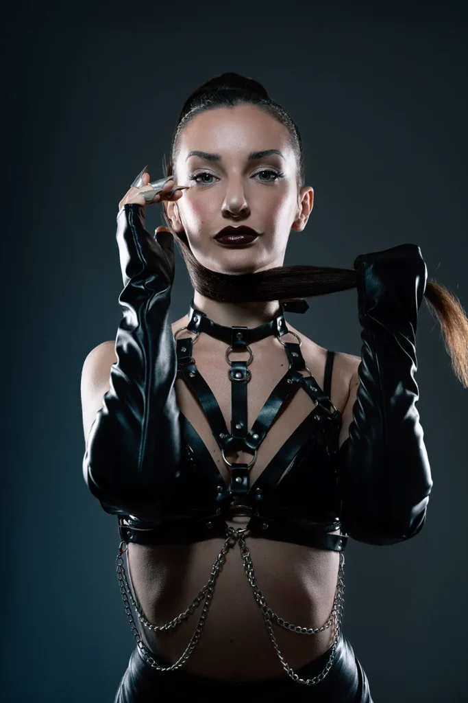 Modelo con coleta alta y arnés de cuero posando para book de fotos profesional con estilo urbano en Palma