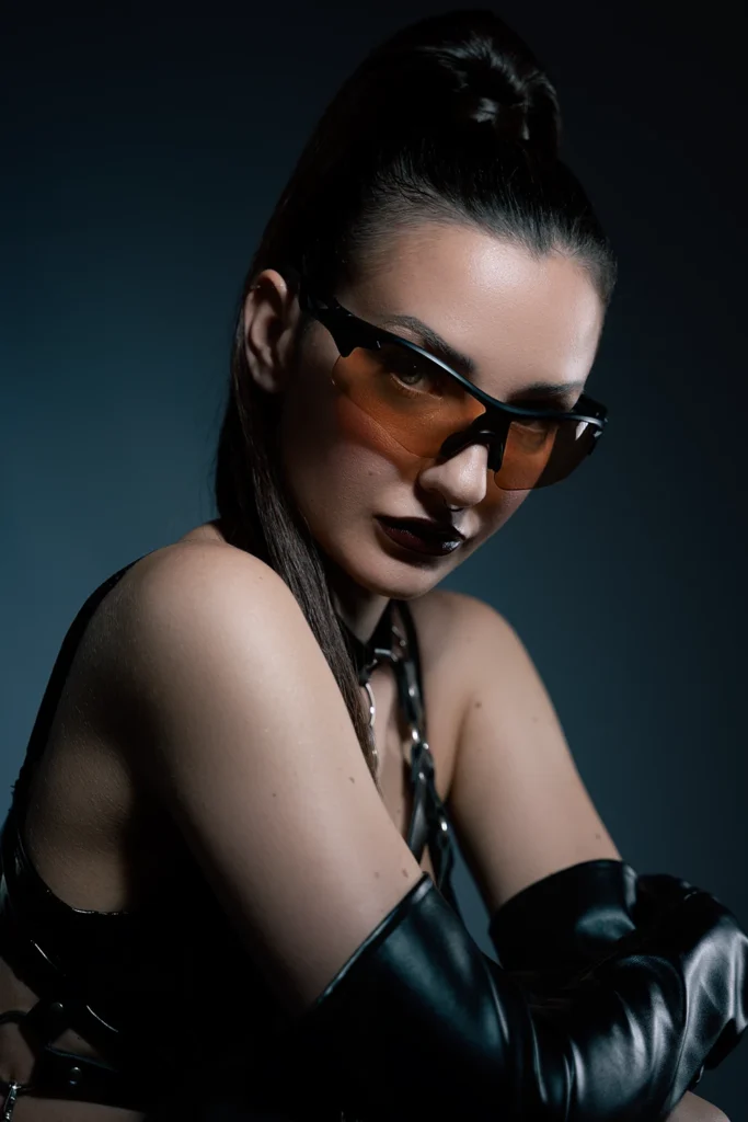 Primer plano de retrato de moda con gafas de sol naranjas, parte de un book fotográfico profesional en Palma.