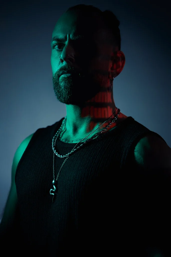 Retrato creativo de DJ Lahox con un proyector de patrones de luz en el rostro.